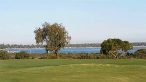 A golf course with a water body in the background. - Dare St Beach Apartment | 2-Min Walk to Beach & Town (Ocean Grove)