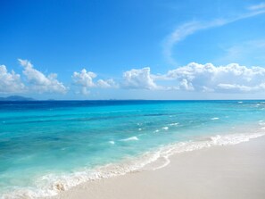 Uma praia com águas turquesa cristalinas e areia branca.