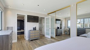 Quarto com uma cama grande, um guarda-roupa e uma porta de armário com espelho.