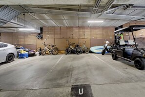 A parking garage with bicycles, a golf cart, and a car. - New photos! Bayfront Penthouse plus parking+bikes! (San Diego)
