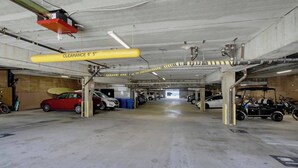 Garagem de estacionamento com vários níveis e sinalização clara, incluindo um aviso de altura máxima.