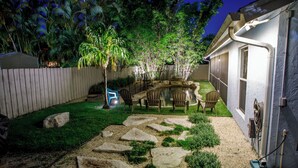 A backyard with a stone pathway, a small pond, and outdoor furniture. - Oasis in the heart of Equestrian country (Wellington)