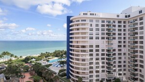 Un hotel moderno con múltiples balcones con vistas a la playa y al océano.