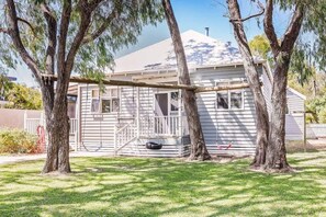 A house with a porch, a swing, and a tire swing.