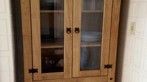 A wooden cabinet with glass doors and drawers, featuring black handles. - House with pool 200 meters from the beach (Prainha)