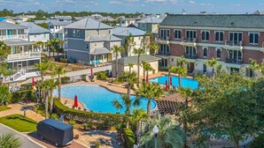 Zona residencial con piscina rodeada de palmeras y un cartel que indica 'The Village Pool', con área exclusiva para huéspedes.