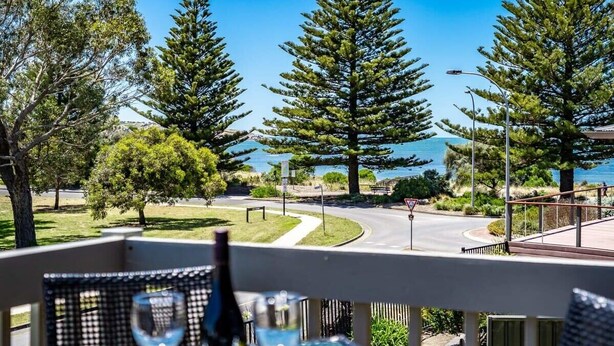 A balcony with a view of a road, trees, and a body of water. - 4/1 Harbour View Terrace - Wi-Fi (Victor Harbor)