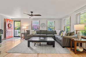 A living room with a sectional sofa, a coffee table, and a ceiling fan. - Perfect Relaxation Spot 5 min to Beach! (Eastham)