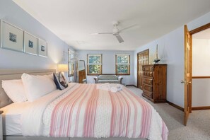 A bedroom with a bed, a dresser, a bench, and a ceiling fan. - Perfect Relaxation Spot 5 min to Beach! (Eastham)
