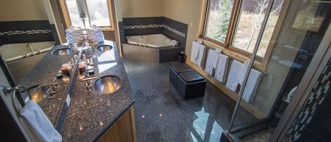 Une salle de bain moderne dotée d’une grande baignoire, d’une douche séparée et d’un meuble-lavabo avec plusieurs vasques.