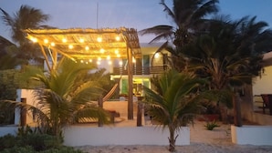 A beachside property with a thatched roof structure, palm trees, and a sandy beach. - Casa Luna. Welcome Family To Enjoy A beautiful beach ! (Chelem)