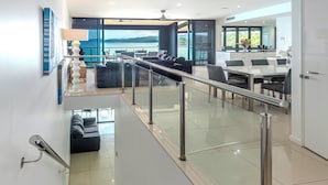 Um interior moderno com uma escada que leva a uma varanda com vista panorâmica.