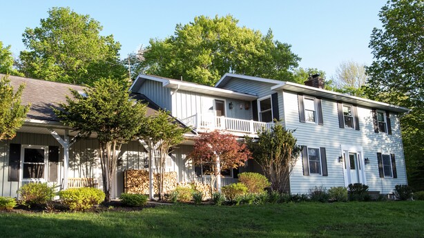 A two-story house with a porch, a covered front entrance, and a well-maintained lawn. - Spacious and comfy, king bed, double futon sofa, kitchen, near Colgate, 7 Oaks (Hamilton)