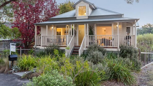 A two-story house with a porch, surrounded by lush greenery and trees. - Time to wind down, hear the birds, the Sea. New EV Charger.
Double Spa Bath. (Lorne)