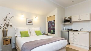 A bedroom with a bed, bedside table, and a small cabinet. There is a window with a view of greenery. - Time to wind down, hear the birds, the Sea. New EV Charger.
Double Spa Bath. (Lorne)