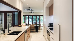 Una cocina moderna con una isla central, electrodomésticos integrados y vistas al exterior.
