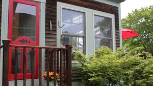 A house with a red door, a wooden porch, and a red umbrella. - Full Moon on the Harraseeket, Freeport, Maine   (Freeport)