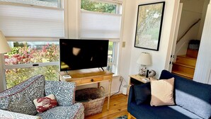 A living room with a sofa, a patterned armchair, a TV on a wooden stand, a lamp, and a map on the wall. - Full Moon on the Harraseeket, Freeport, Maine   (Freeport)