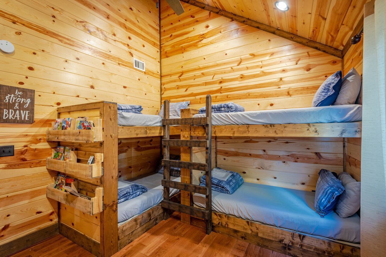Una cabaña con literas, paredes de madera y una escalera.