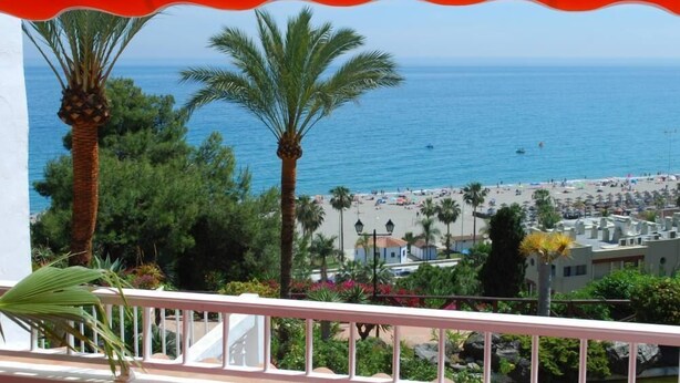 A balcony with a view of a beach and ocean.