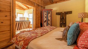 Une pièce de cabane en bois comprenant un lit, une armoire et une décoration murale rustique.