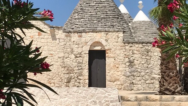 Un edificio de piedra con puerta negra y detalles decorativos blancos.