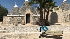 Un edificio de piedra con tejados cónicos y una silla de lounge al frente.