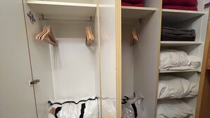 Um closet espaçoso com prateleiras abertas, espaço para pendurar roupas e itens dobrados.