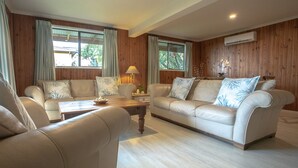 Sala de estar com dois sofás, uma mesa de centro e um abajur.