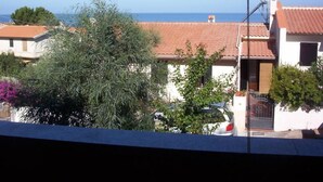 Un barrio residencial con casas, un coche y una vista despejada al mar.