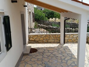Relax in this serene outdoor space, surrounded by lush greenery and a stone wall.