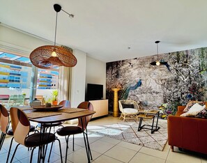 A modern living room with a dining area, a large window, and a mural on the wall. - Luxurious accommodation with large terrace and stunning sea views (Torre del Mar)