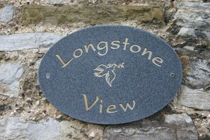 A circular stone plaque with the inscription "Longstone View" and a floral design.