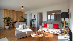 A modern living room with a sofa set, a coffee table, and potted plants.