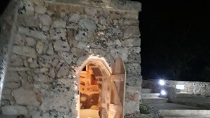 A stone building with an arched entrance, a staircase leading inside, and a paved area in front. - Puglia Salento luxury villa with swimming pool and hydro spa. a few km from leuca  (alessano)