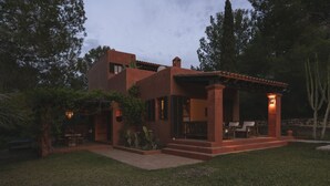 A modern house with a patio, surrounded by trees and cacti. - Cana Lúa. Charming Villa With Fantastic Sea View And Sunset (Sant Josep de sa Talaia)