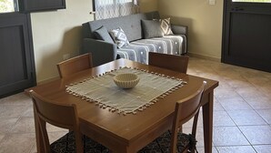 Un coin repas avec une table et des chaises en bois, un chemin de table à motifs et un bol décoratif.