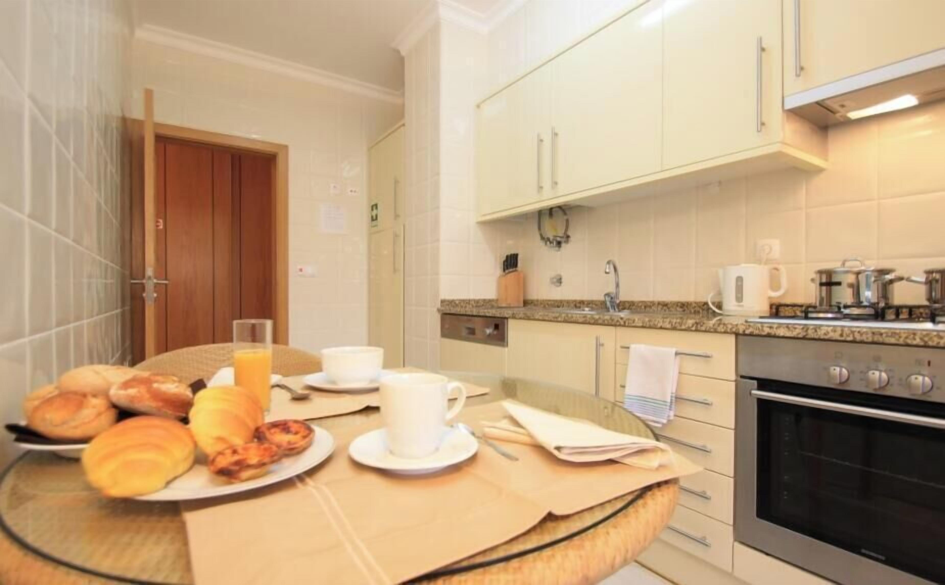 A small kitchen with a dining area, a stove, and a coffee maker.