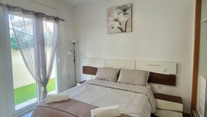 A bedroom with a bed, a ceiling fan, a painting, and a window with curtains. - Modern 2 Bed Detached Villa | Private Pool | Near Quesada | Peaceful Location  (Rojales)