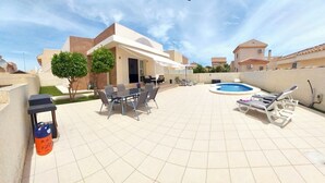 A spacious outdoor patio with a pool, a dining area, and lounge chairs. - Modern 2 Bed Detached Villa | Private Pool | Near Quesada | Peaceful Location  (Rojales)