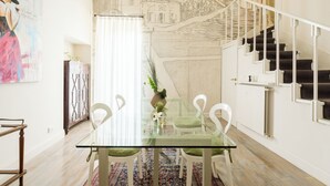 A dining area with a glass table, white chairs, a patterned rug, and a staircase with white railings. - Hidden Gem on the Spanish Steps - Terrace - Great Air Conditioning (Roma)