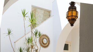 Un patio con una mesa, sillas, un espejo decorativo y un frutero.