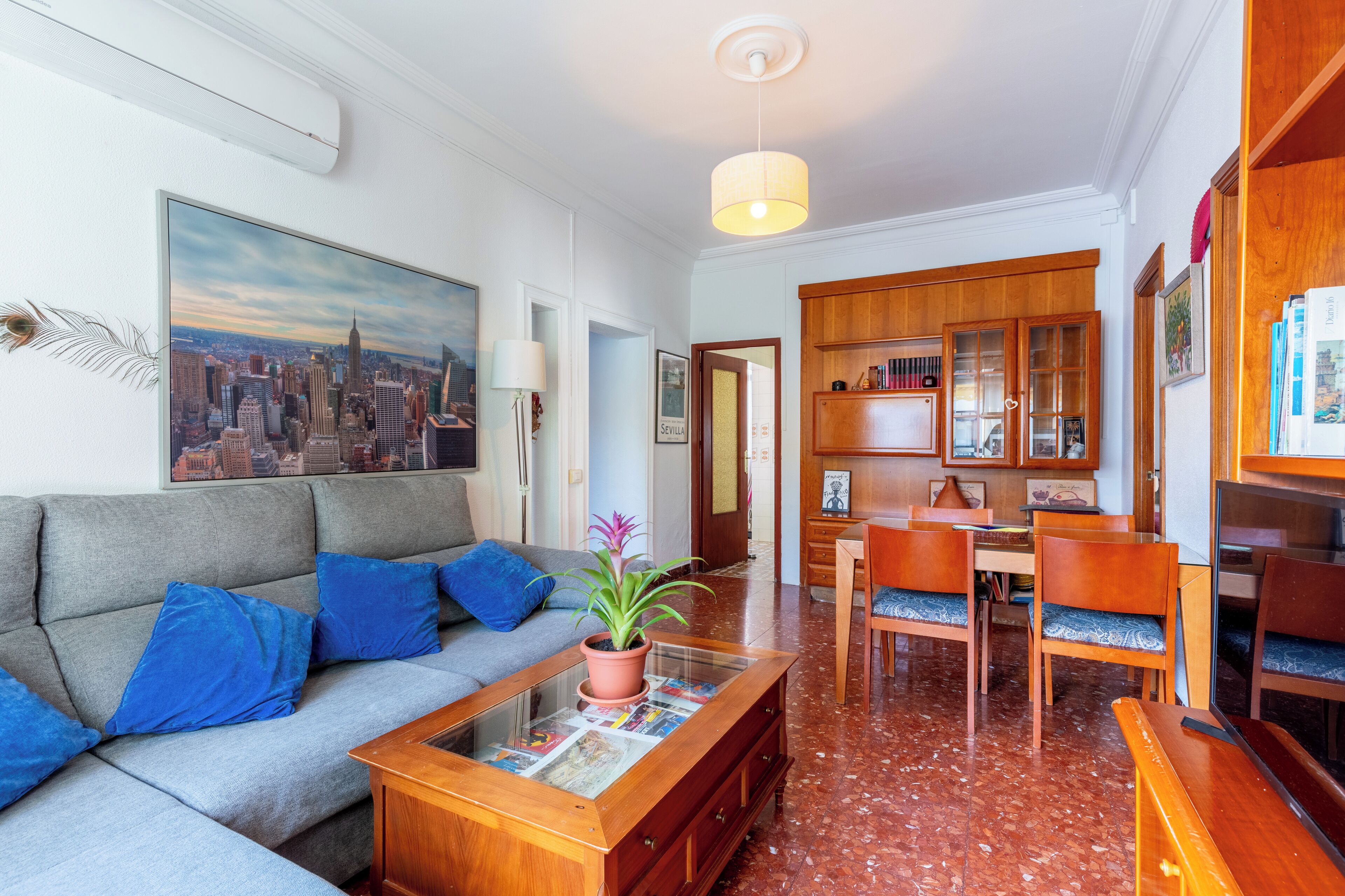 Una sala de estar con sofá, una mesita de centro y un cuadro de la ciudad.
