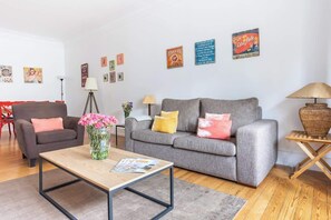 A living room with a grey sofa, a brown armchair, a coffee table, and a lamp.