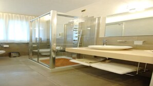 A modern bathroom with a glass shower enclosure, a sink with a mirror, and a toilet. - Apartment Dante Residence 2 (Mantova)