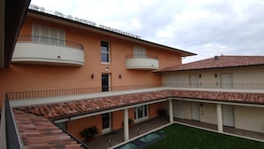 A two-story building with a flat roof and a central courtyard. - Apartment Dante Residence 2 (Mantova)