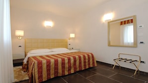 A hotel room with a bed, two bedside lamps, a large mirror, and a small table. - Apartment Dante Residence 2 (Mantova)