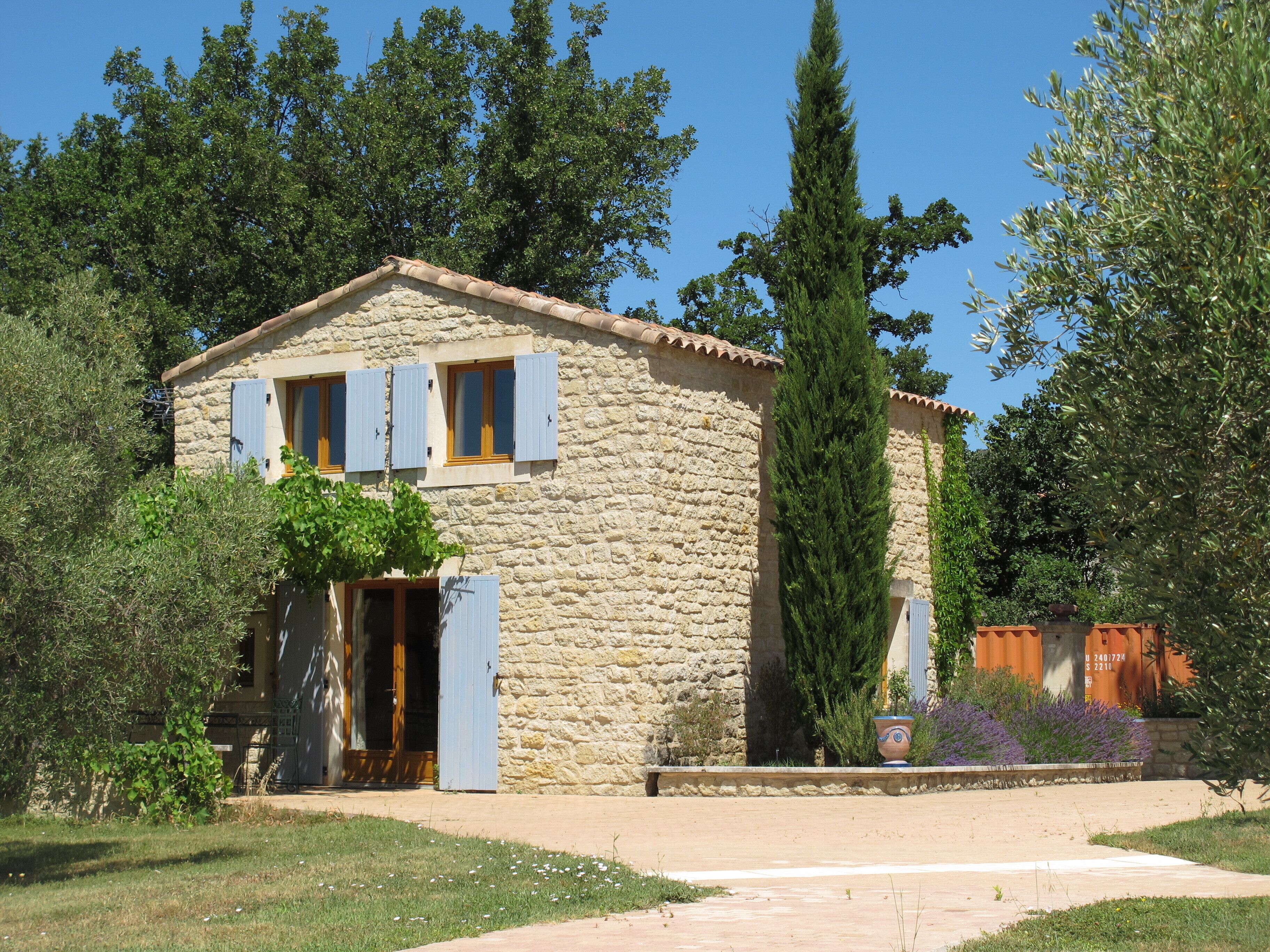 A stone house with a tiled roof, a wooden door, and a small porch.