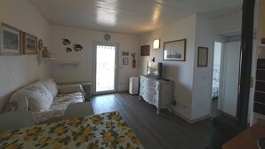 Ein Schlafzimmer mit Bett, Kommode, Fernseher und Fenster.