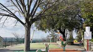 A playground with swings, a seesaw, and a climbing structure.